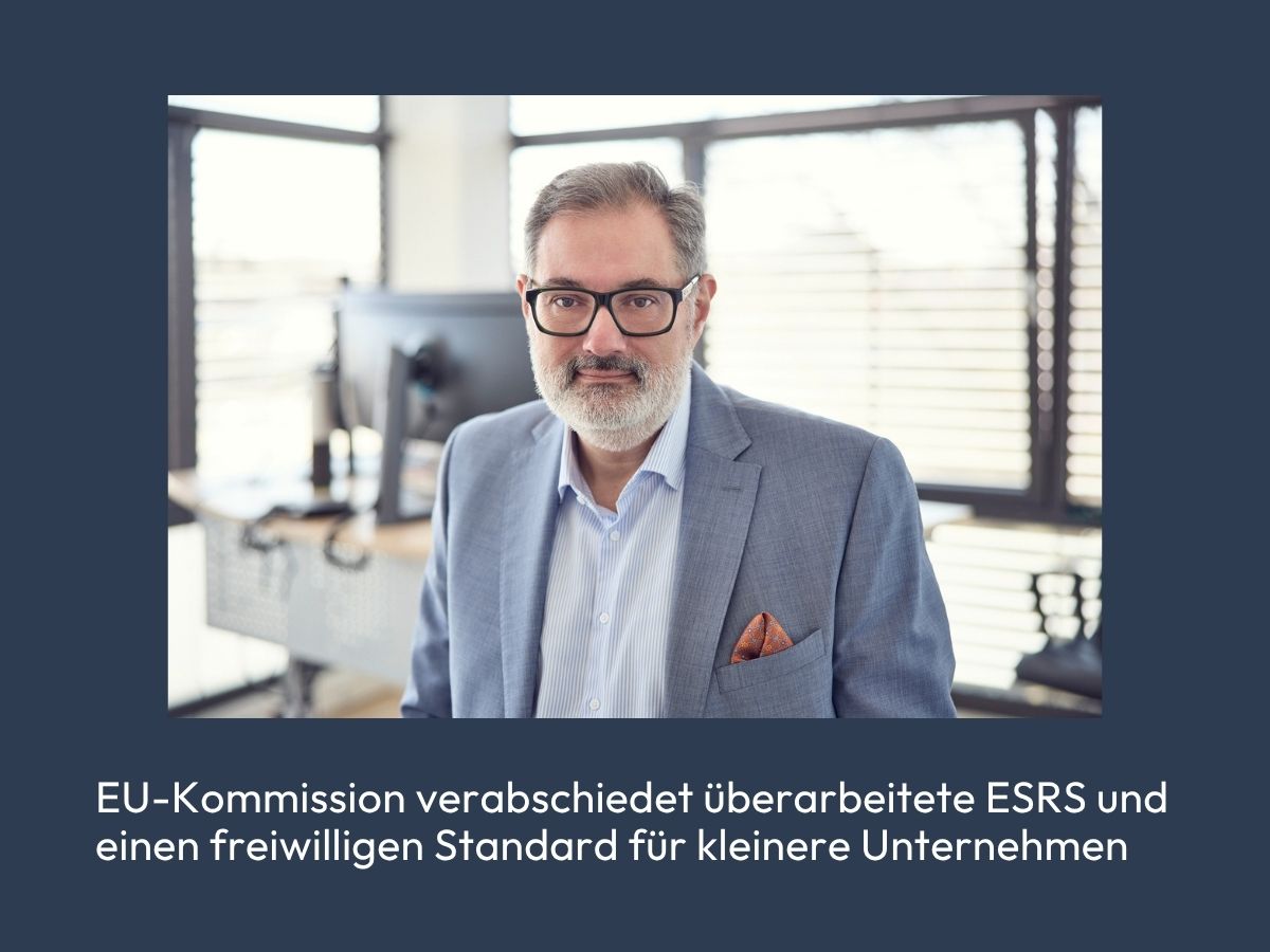 Ein Mann mit Brille und grauem Bart steht in einem modernen Büro, während er in die Kamera schaut. Im Hintergrund sind ein Computer und Fenster sichtbar. Der Text auf dem Bild besagt, dass die EU-Kommission überarbeitete ESRS und einen freiwilligen Standard für kleinere Unternehmen verabschiedet hat.
